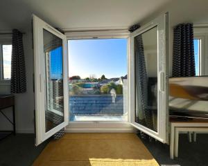 a room with a large window with a view at Seascape - Stylish Modern apartment in Barton on Sea