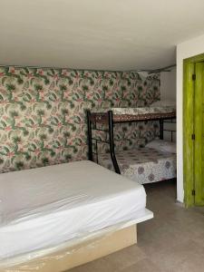 una camera da letto con un letto e una parete ricoperta di carta da parati di FINCA HOTEL TIERRA NUEVA CAMPESTRE a La Vega
