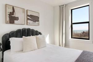 1 dormitorio con 1 cama blanca y ventana en 1BR Chic & Elite Apt in Hyde Park - Shoreland 714 en Chicago