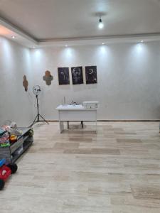 um quarto branco com uma mesa e quadros na parede em Res Brahim AL Farrah em Casablanca