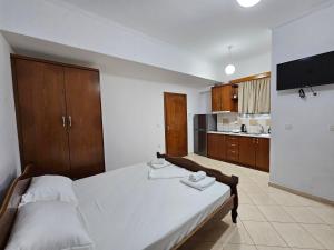 a bedroom with a large bed and a kitchen at Guest House Bledar in Ksamil