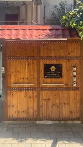 um portão de madeira para um restaurante com um sinal nele em Grandpa House - App.3 em Tirana