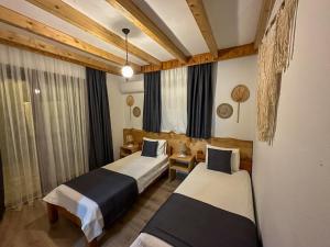 a hotel room with two beds and a window at Faralya Misafir Evi in Faralya