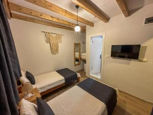 a room with two beds and a flat screen tv at Faralya Misafir Evi in Faralya