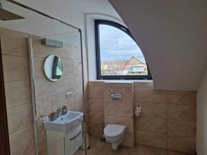 a bathroom with a window and a toilet and a sink at Noclegi Nad rzeką Białą in StrÃ³Å¼e