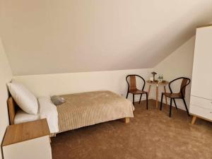 um quarto com uma cama, uma mesa e cadeiras em Noclegi Nad rzeką Białą em StrÃ³Å¼e