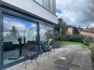 two chairs sitting on a patio in front of a building at Schillerhöhe Luxury-Hideout - Traumblick mit viel Platz und Privatsphäre in Gerlingen