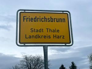 a yellow street sign that reads firefightingrhythmadinadinadin stick taller landmarks at Böhms Ferienwohnungen in Friedrichsbrunn