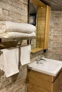 uma casa de banho com lavatório, espelho e toalhas em Dana luxury huts em Dana