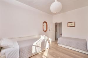 biała sypialnia z 2 łóżkami i lustrem w obiekcie Antica Casa del Segretario w mieście Serramonacesca