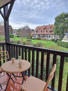 ヴィレ・シュル・メールにあるAppartement Cosy Villers-Sur-Merの眺めの良いバルコニーにテーブルと椅子が置かれている