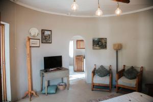 a living room with a television and a table and chairs at Langside Rondawel in Queenstown