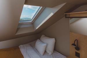 un letto con cuscini bianchi in una stanza con finestra di Han Sylte Heimen a Fauske