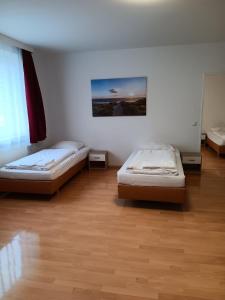 2 camas en una habitación con suelo de madera en Othman Appartements Anderter Straße 55g, 1 OG L en Hannover