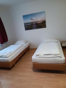 2 camas en una habitación con una foto en la pared en Othman Appartements Anderter Straße 55g, 1 OG L en Hannover