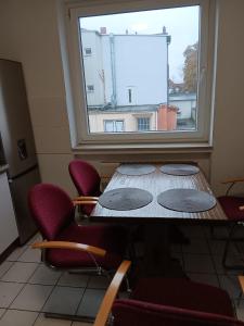 einen Tisch und Stühle in einem Zimmer mit Fenster in der Unterkunft Othman Appartements Anderter Straße 55g, 1 OG L in Hannover