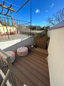 un balcone con 2 sgabelli su una terrazza in legno di Rifugio99 Firenze - Giardini di Boboli a Firenze