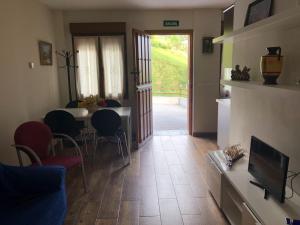 a living room with a table and chairs and a television at Apartamentos Miravalles A in Villaviciosa