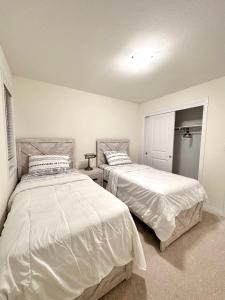 2 camas en un dormitorio con sábanas blancas en Entire Home In Niagara Falls, Canada en Niagara Falls