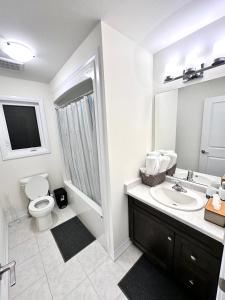 a white bathroom with a toilet and a sink at Entire Home In Niagara Falls, Canada in Niagara Falls