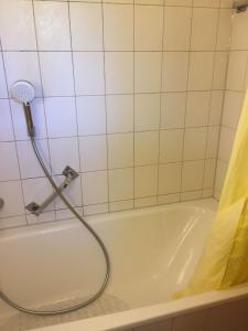 uma banheira com uma cabeça de chuveiro na casa de banho em Ferienwohnung 3 in Huglfing im Herzen des 5 Seen Land Oberbayerns em Huglfing