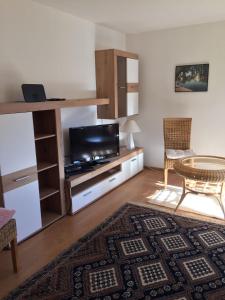 uma sala de estar com uma televisão e uma mesa em Ferienwohnung 3 in Huglfing im Herzen des 5 Seen Land Oberbayerns em Huglfing