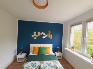 a bedroom with a blue accent wall and a bed at Apartament Słoneczna in Mrzeżyno