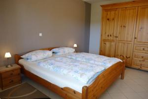 1 dormitorio con 1 cama y armario de madera en Ferienwohnung Basche, en Oberzissen