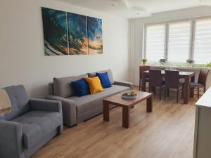 a living room with a couch and a table at Apartament Słoneczna in Mrzeżyno