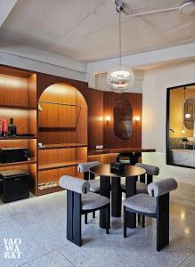 a dining room with tables and chairs in a room at Yaowarat Stay in Bangkok