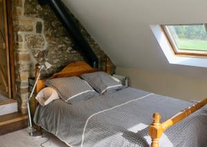 a bedroom with a bed with a stone wall at Une maison à la campagne in Saint-Mars-sur-la-Futaie