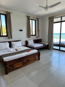 a bedroom with two beds and a view of the ocean at YU Resort in Msambweni