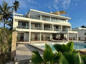 Msambweni的住宿－YU Resort，一座白色的大建筑,前面设有一个游泳池