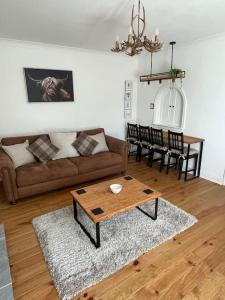 a living room with a couch and a table at Daisy Cottagee in Alyth