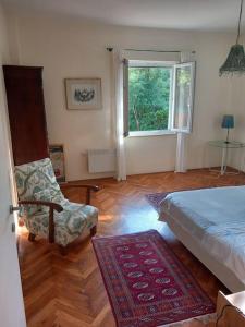 a bedroom with a bed and a chair and a window at Petra's House in Komaji