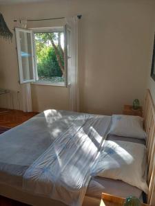 a large bed in a bedroom with a window at Petra's House in Komaji