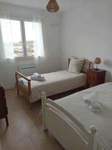 1 dormitorio con 2 camas y ventana en Appartement Auzances, en Auzances