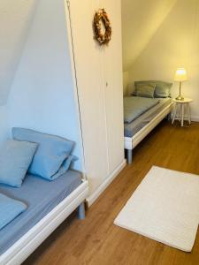 MoormerlandにあるFerienwohnung Wiekenblickの青い枕が付いたベッド2台が備わる客室です。