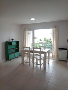 a dining room with a table and chairs and a window at Departamento Del Valle in Tandil