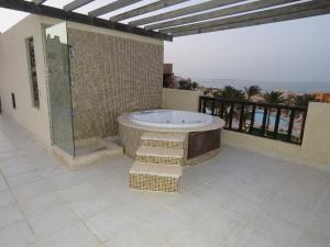 a bathroom with a bath tub and a balcony at Azzurra two-Bedroom Apartment at Sahl Hasheesh in Hurghada