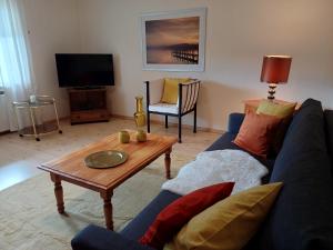 uma sala de estar com um sofá azul e uma mesa de centro em Ambiente em Homberg