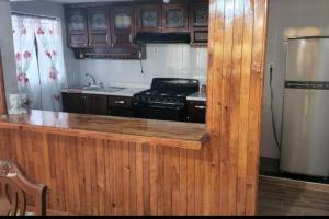 een keuken met een houten aanrechtblad en een koelkast bij Casa el Nogalito in Tasquillo