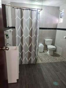 een badkamer met toilet en douchegordijn bij Casa el Nogalito in Tasquillo