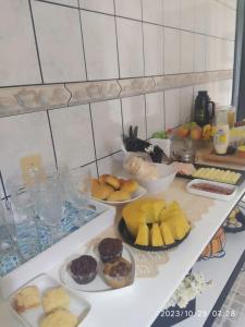 eine Theke mit vielen verschiedenen Arten von Speisen auf Platten in der Unterkunft Sótão Oktoberfest in Blumenau