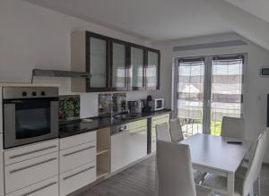 a kitchen with white cabinets and a table with chairs at Kempf Apartments in Rust