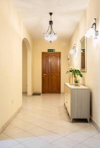 a hallway with a wooden door and a table at Aurora Apartment in Żurrieq