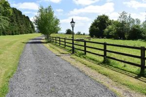 una carretera rural con una valla y una lámpara en Lackandarralodge large 5BR entire house sleeps14!, en Dungarvan