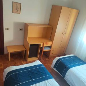 Schlafzimmer mit einem Schreibtisch, einem Bett und einem Schrank in der Unterkunft Hotel oro in Cento