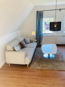 ein Wohnzimmer mit einem Sofa und einem Tisch in der Unterkunft Ferienwohnung Wiekenblick in Moormerland