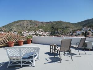 a patio with two chairs and a table on a roof at In the heart of Hydra in Hydra